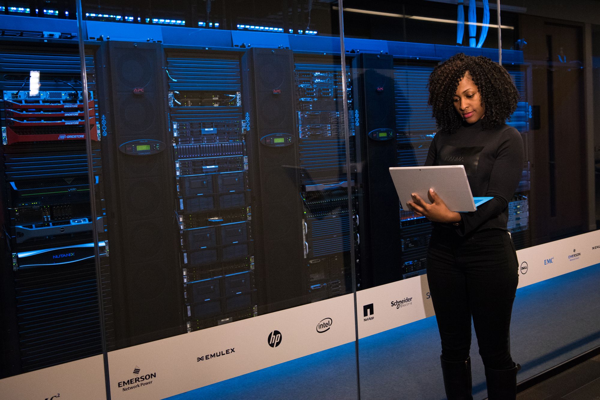 Black woman engineer in server room with laptop